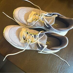 On Running Cream and Yellow Athletic Shoes